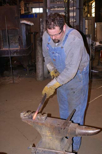 blacksmith-hold-hot-iron-over-anvil